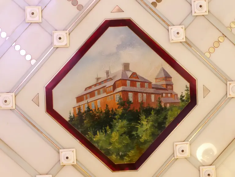 Bemalte Deckenfliese von Villeroy & Boch: Gebäude im Wald, gerahmt von einem roten Achteck